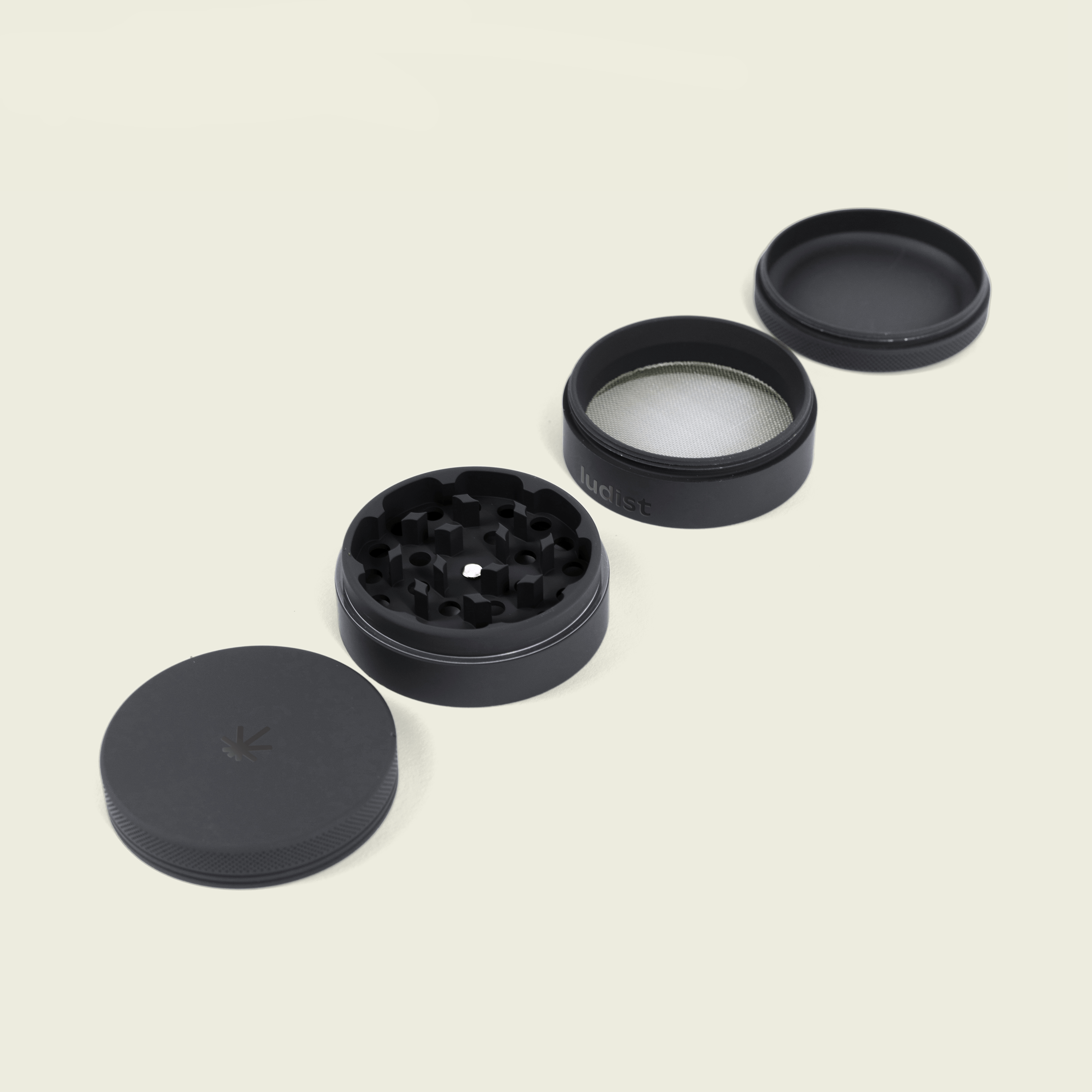 Black grinder with multiple parts on a light background