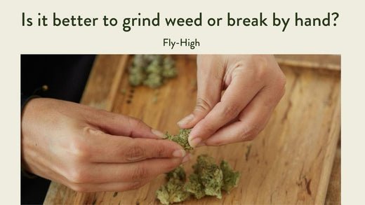 Close-up of hands breaking apart cannabis buds on a wooden tray, with the title 'Is it better to grind weed or break by hand?' above.